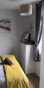 ein Schlafzimmer mit einem gelben Bett und einer Kommode in der Unterkunft 83A South Shore Village in Bridlington