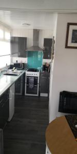 eine Küche mit Geräten aus Edelstahl und einem Tisch in der Unterkunft 83A South Shore Village in Bridlington