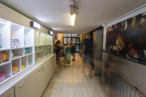 a hallway of a store with people sitting at tables at Aldea Hostel in Córdoba