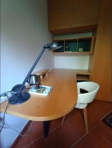 a desk with a lamp sitting on top of it at Camera nella Casa dei Tigli in Treviso