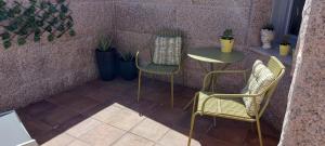 un patio con 2 sillas, una mesa y una mesa en Stone House Premium Suite, en Porriño