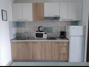 a kitchen with a white refrigerator and a microwave at ApartmanA&J1111 in Kaštela