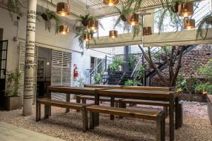 a group of benches sitting inside of a building at Aldea Hostel in Córdoba