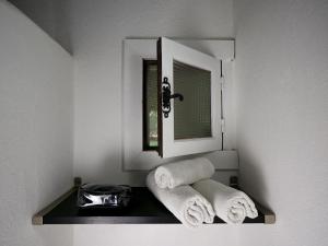 ein Badezimmer mit Handtüchern auf einem Regal unter einem Spiegel in der Unterkunft MAS MLS in Saintes-Maries-de-la-Mer