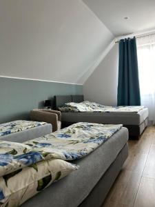 3 camas en una habitación con cortinas azules en Pensjonat Zatoka 17, en Władysławowo
