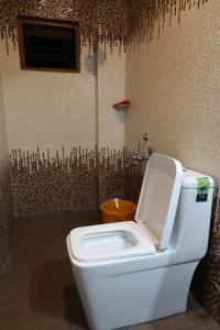 a toilet with the lid up in a bathroom at Ammukutty's Cottage in Munnar