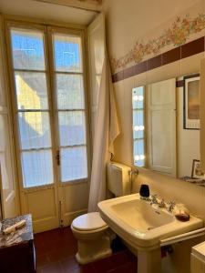 a bathroom with a sink and a toilet and a mirror at Elegant apartment inside Villa Fontana in Tremezzo