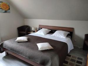 a bedroom with a large bed with two pillows on it at Chambres d'Hôtes Arnold in Dambach-la-Ville