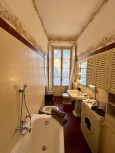 a bathroom with a tub and a toilet and a sink at Elegant apartment inside Villa Fontana in Tremezzo