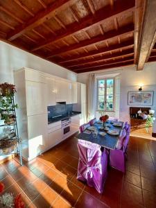 a living room with a table and purple chairs at Elegant apartment inside Villa Fontana in Tremezzo