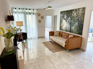 una sala de estar con sofá y una pintura en la pared en Las Olas DM cozy 2-bedrooms apartment en Maspalomas