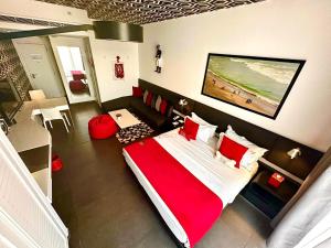 a bedroom with a large bed with red pillows at The Smallville Hotel in Beirut