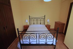 1 dormitorio con 1 cama negra y 2 mesitas de noche en La Casita Amarilla, en Los Molinos