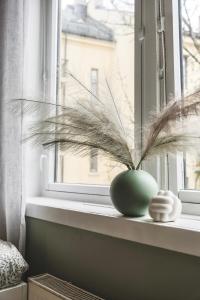 a green vase sitting on a window sill with a plant at Newly renovated studio apartment at Frogner in Oslo