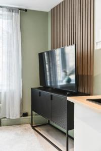 a flat screen tv sitting on top of a entertainment center at Newly renovated studio apartment at Frogner in Oslo
