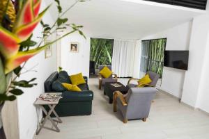 a living room with two couches and a tv at Hotel campestre La Floresta in Armenia