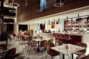 un ristorante con tavoli e sedie e un bar di Elysia park rose apartment a Paphos