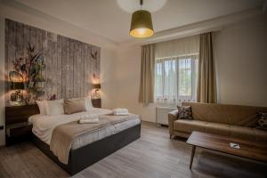 a bedroom with a bed and a couch at Hotel Golden Palace in Göd