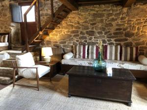 uma sala de estar com um sofá e um vaso sobre uma mesa em Hotel Rural Casal do Mouro em Ambroa