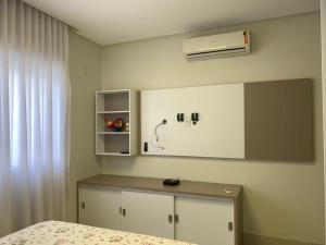 ein Zimmer mit einem Schlafzimmer mit einem Bett und einer Wand mit einem Spiegel in der Unterkunft Casa de luxo alphaville in Goiânia
