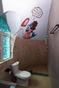 a bathroom with a toilet with a painting on the wall at Atlantis Villa Best homestay malaka in Kampong Alor Gajah