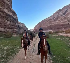 a group of people riding horses down a dirt road at Mahmmad Luxury Camp in Disah