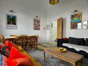 a living room with a couch and a table at Gensing Lodge - A Beautiful Artistic Maisonette in St. Leonards