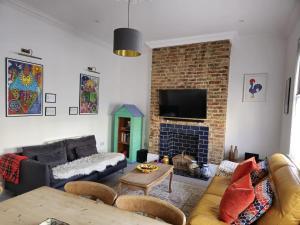 a living room with a couch and a fireplace at Gensing Lodge - A Beautiful Artistic Maisonette in St. Leonards