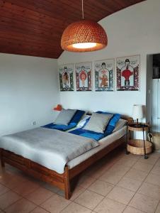 um quarto com uma cama com lençóis azuis e um tecto em P & P Nyaraló em Szigliget