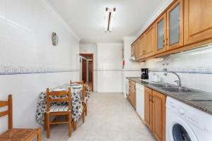 a kitchen with a sink and a washing machine at BLife Vitorya private rooms in Faro