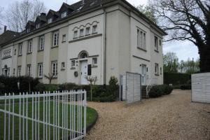 een wit huis met een hek ervoor bij Luxuriöse Wohnung in Schwerte in Schwerte