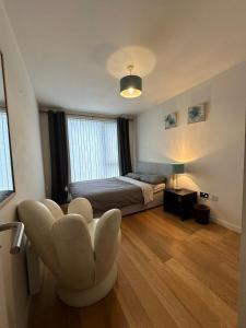 1 dormitorio con 1 cama y 1 silla en The Fitz Apartment, en Dublín