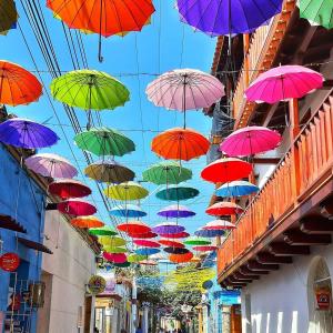 a bunch of colorful umbrellas hanging from a ceiling at Casa Centenario in Cartagena de Indias