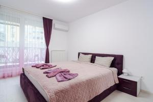 Un dormitorio con una cama con toallas rosas. en Paris luxury top centre Apt with office space en Sofía