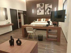 1 dormitorio con 1 cama y escritorio con TV en Hotel El Salvador, en Ciudad de México