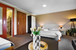 a bedroom with a bed and a vase of flowers on a table at Pension Růžák in Růžová