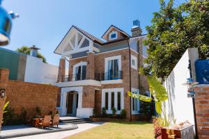 a house with a brick and white facade at Đại Nam Villa in Buon Ma Thuot