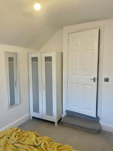 a bedroom with two closets and a door at Cosy Vibes Central Cardiff House in Cardiff