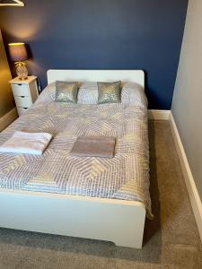 a white bed in a bedroom with a blue wall at Cosy Vibes Central Cardiff House in Cardiff