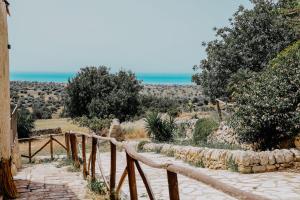 un camino que conduce a una playa con árboles y el océano en Agriturismo Balcone Mediterraneo - Camere, en Ragusa