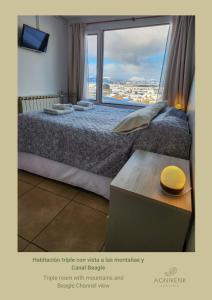 a bedroom with a bed with a large window at Hostería Aonikenk in Ushuaia