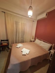 a bedroom with a bed with two towels on it at Valerias house in Aígio