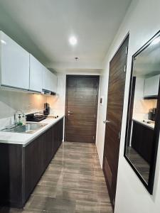 Una cocina con fregadero y puerta de madera. en Heart of Makati, Fully furnished condo, cbd central location, en Manila