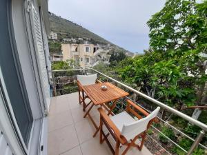 a balcony with a wooden table and chairs at Meto Rooms in Sarandë
