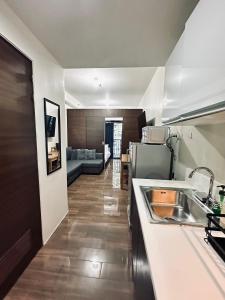 uma cozinha com um lavatório e uma sala de estar em Heart of Makati, Fully furnished condo, cbd central location em Manila