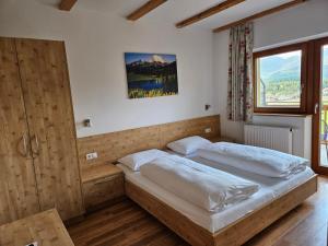 sypialnia z 2 łóżkami i dużym oknem w obiekcie Apartment Pichlerhof w mieście San Lorenzo di Sebato +37 zdjęć