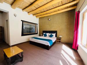 1 dormitorio con cama y techo de madera en HUNDER TAMARIX RESORT en Leh