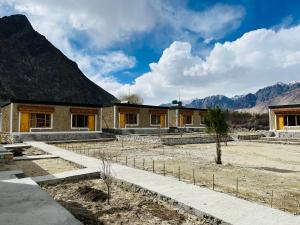 a house under construction with mountains in the background at HUNDER TAMARIX RESORT in Leh