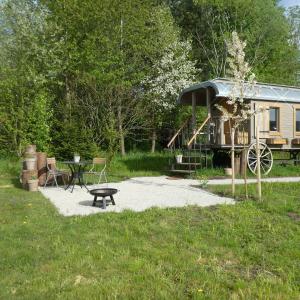 uma pequena casa com uma mesa de piquenique e um parque infantil em Entspannung im Zirkuswagen: außergewöhnliche und liebevoll eingerichtete Glamping-Unterkunft im Grünen em Geigant