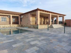 une maison avec une piscine en face d'une maison dans l'établissement EL SECRETO DE LOS PERALES, à Velada